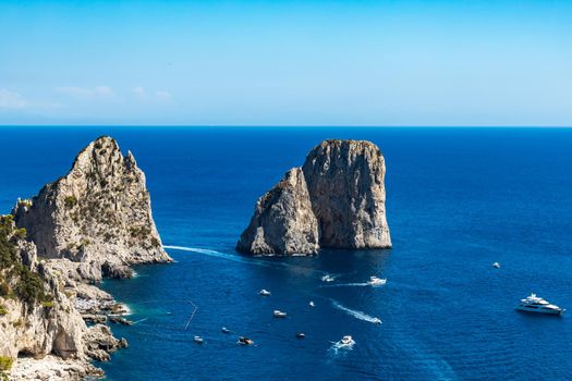 Beautiful panorama of small bay full of small ships and boats next to 
Faraglioni di Mezzo
 and Capri island 