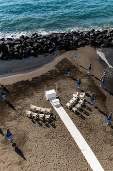 Preparations of wedding party on small beach next to sea and big rocks