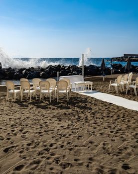 Preparations of wedding party on small beach next to sea and big rocks