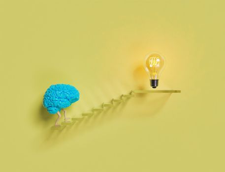 blue brain climbing stairs with an illuminated light bulb at the top. 3d render