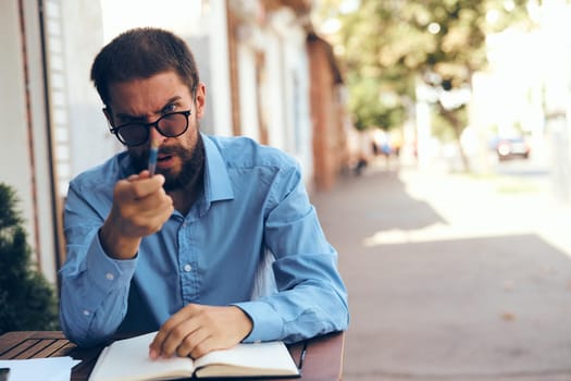 business man with glasses sitting at a table in a cafe work emotions. High quality photo