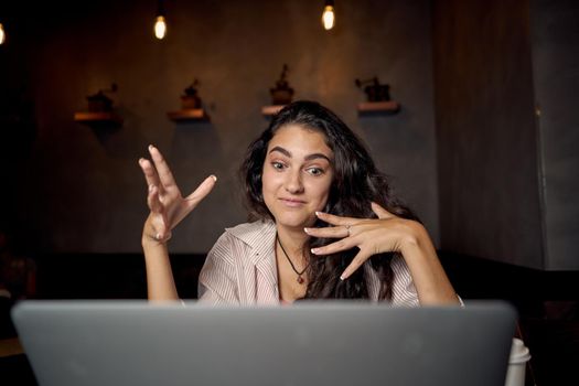 woman in a cafe at a table in front of a laptop device communication. High quality photo