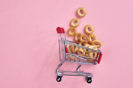 small shopping carts supermarket shopping pink background. High quality photo