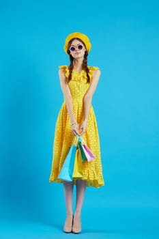 smiling woman with multicolored bags posing blue background. High quality photo