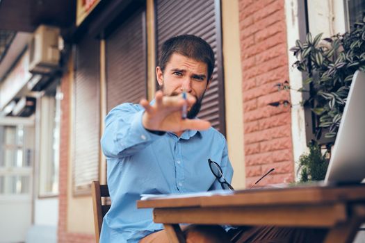 business man outdoors with laptop in cafe emotions. High quality photo