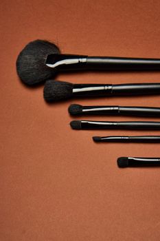 makeup brushes mascara accessories glamor brown background. High quality photo