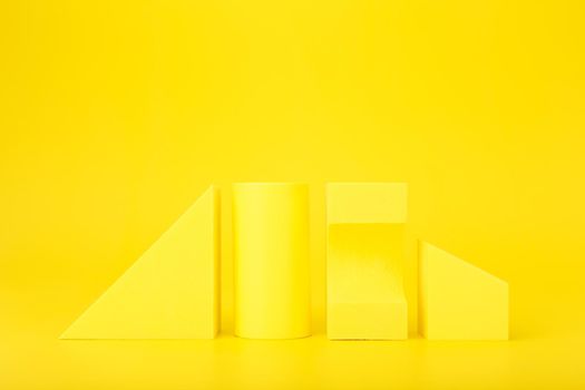 Abstract trendy futuristic background in monochromatic yellow colors with copy space. Bright artsy background with yellow geometric shapes against yellow background with copy space