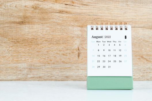 The August calendar 2022 on wooden background.