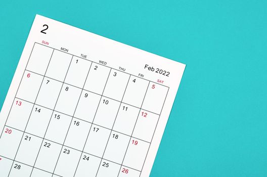 Close up February 2022 calendar sheet on green background.