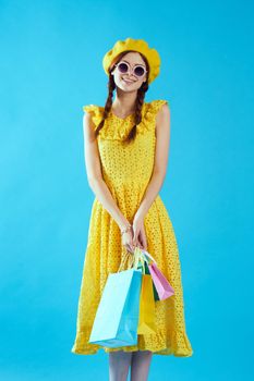 smiling woman with multicolored bags posing blue background. High quality photo