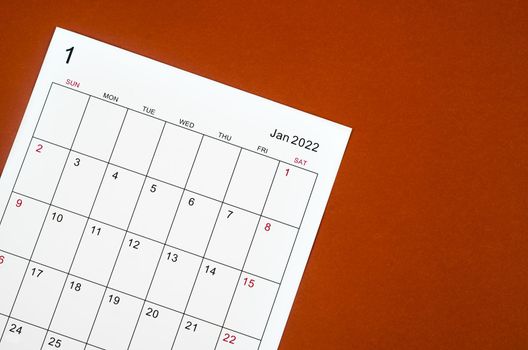 Close up January 2022 calendar sheet on red background.