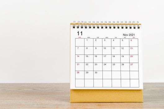 November desk calendar 2021 on wooden background.