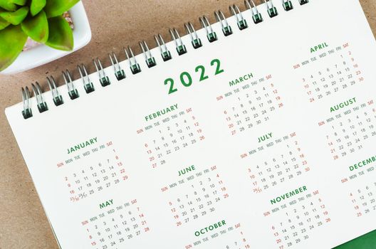 12 months desk calendar 2022 on wooden background.