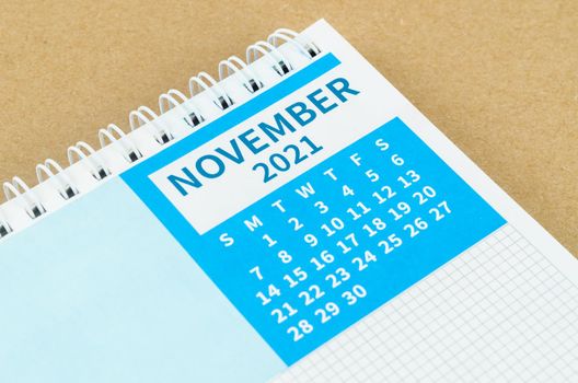 The November 2021 desk calendar on brown background.