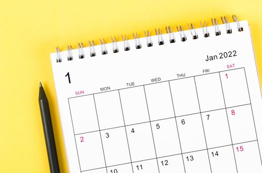 Close-up January 2022 desk calendar on yellow background.