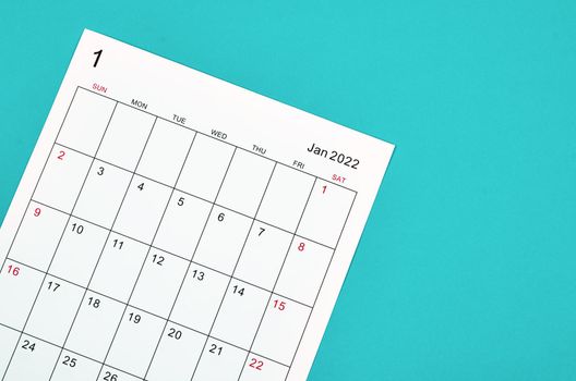 Close up January 2022 calendar sheet on green background.