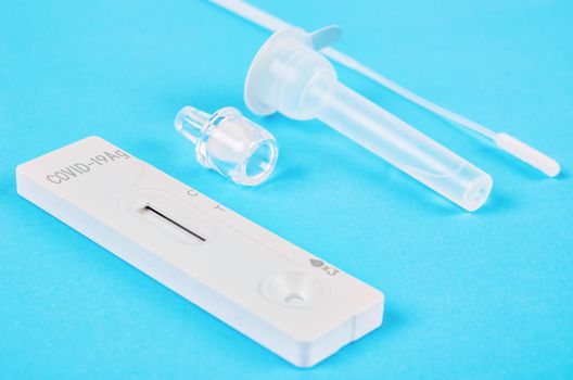 Rapid kits of Covid-19 Ag test seen on blue background.