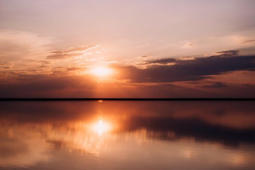 sunset on the shore of a pink lake salt deposit