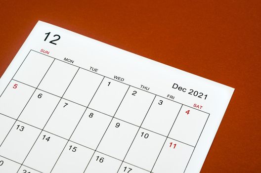 Close up December 2021 calendar sheet on red background.