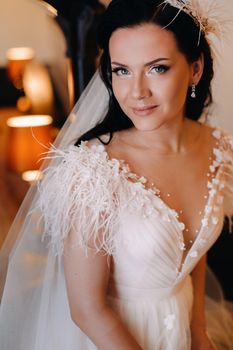 Portrait of the Bride in a wedding dress in the interior of the house near the mirror.