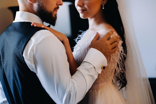 Morning of the bride. The groom stands with the bride near the mirror.