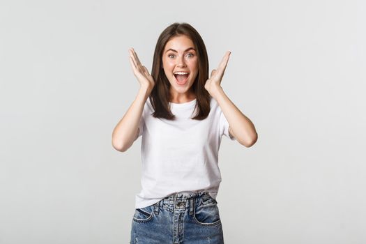Excited happy young woman rejoicing from good news, smiling cheerful.