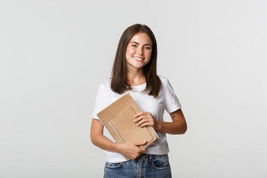 Happy smiling girl student holding notebooks, apply for courses or university.