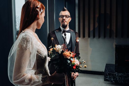 Stylish wedding couple in the interior. Glamorous bride and groom.