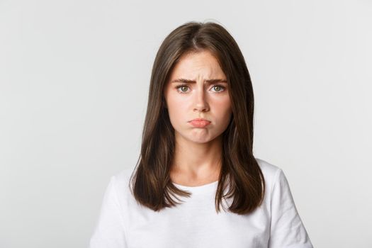 Close-up of sad brunette girl sulking and looking upset.
