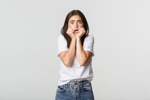 Scared young woman looking terrified, screaming and gasping alarmed.