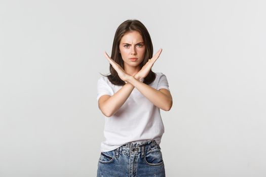 Serious angry woman showing cross, stop something bad, express disapproval or dislike.