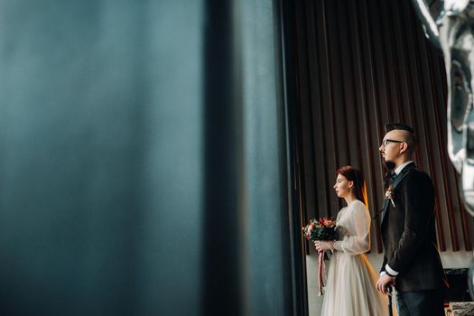 Stylish wedding couple in the interior. Glamorous bride and groom.