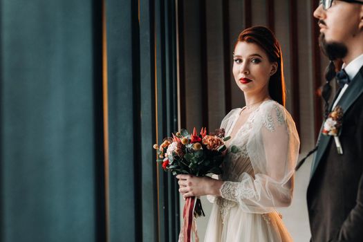 Stylish wedding couple in the interior. Glamorous bride and groom.