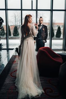 Stylish wedding couple in the interior. Glamorous bride and groom.