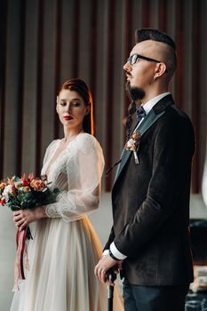 Stylish wedding couple in the interior. Glamorous bride and groom.