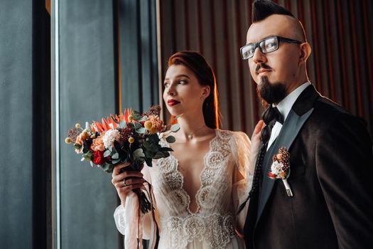 Stylish wedding couple in the interior. Glamorous bride and groom.