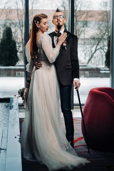 Stylish wedding couple in the interior. Glamorous bride and groom.