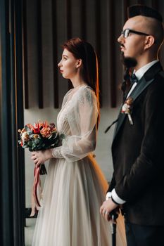 Stylish wedding couple in the interior. Glamorous bride and groom.