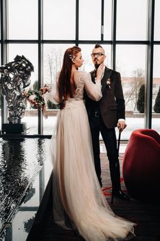 Stylish wedding couple in the interior. Glamorous bride and groom.