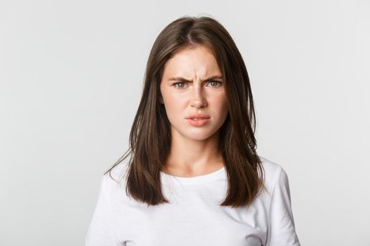 Close-up of skeptical and displeased attractive girl shaking head in rejection, frowning disappointed.