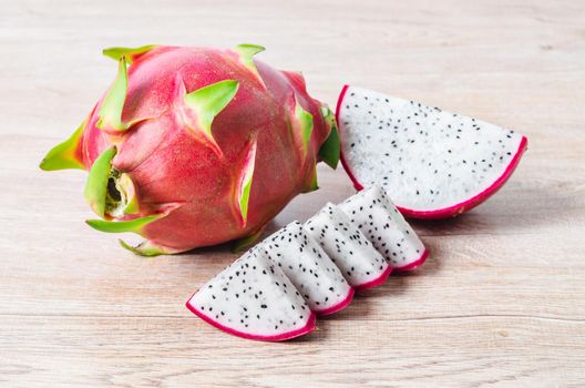 Fresh dragon fruit slice on wooden background.