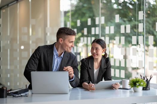 Diverse business people working together with laptop and digital tablet in office meeting room