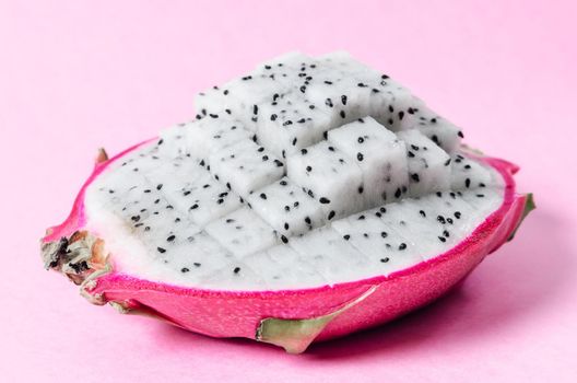 Fresh dragon fruit slice on pink background.