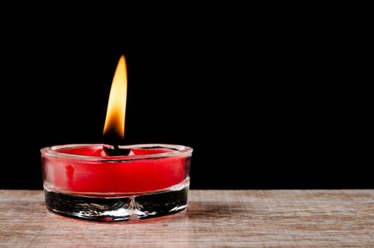 Red Candle Burning on night black background.