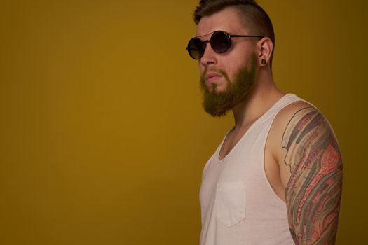 man in a white t-shirt tattoos on his arms fashion glasses modern style. High quality photo
