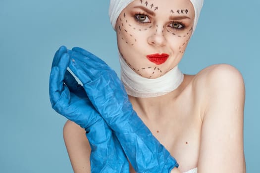female patient posing in blue gloves red lips surgery facial rejuvenation studio lifestyle. High quality photo