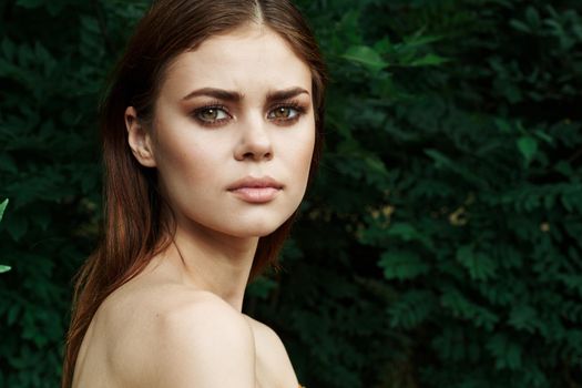 smiling woman in a field outdoors bare shoulders clear skin cropped view. High quality photo