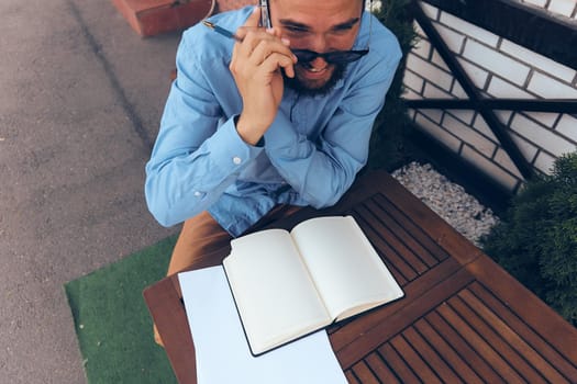 business man with glasses sitting at a table in a cafe work emotions. High quality photo