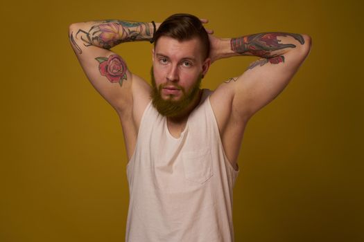 macho man in white t-shirt tattoos on his arms posing isolated background. High quality photo