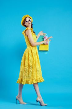 smiling woman in a yellow hat Shopaholic fashion style blue background. High quality photo